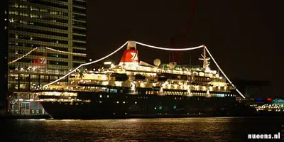 Een cruiseschip achter Amsterdam CS